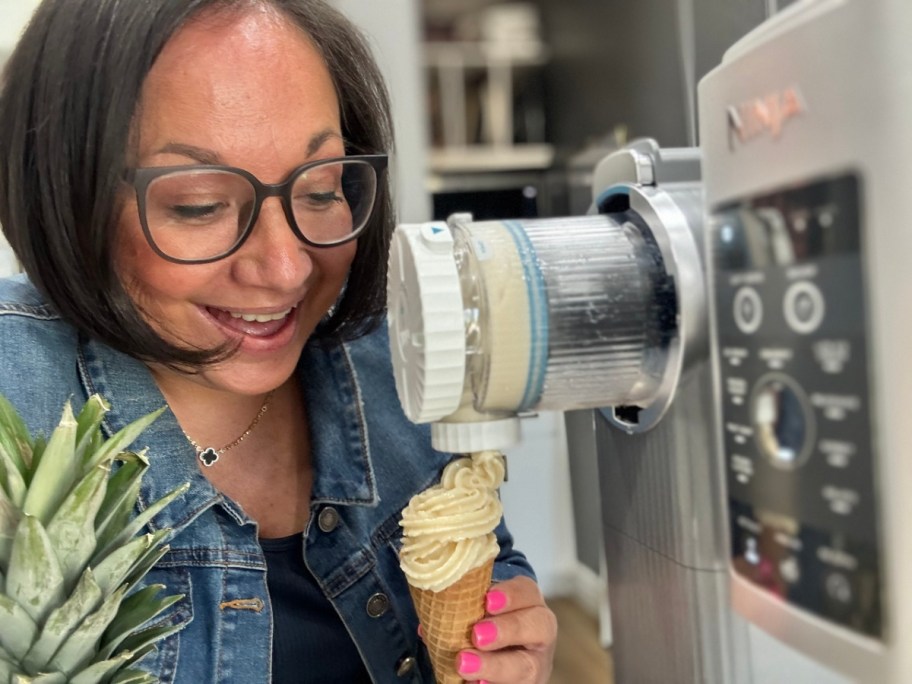 woman loking at an ice cream cone in front of a ninja swirl machine