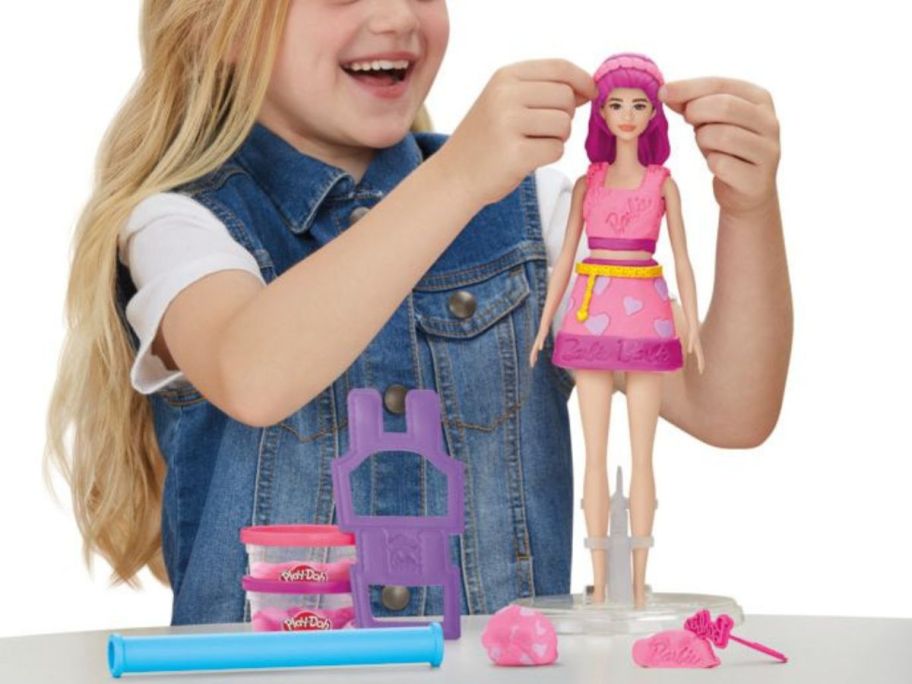 girl playing with barbie play-doh set