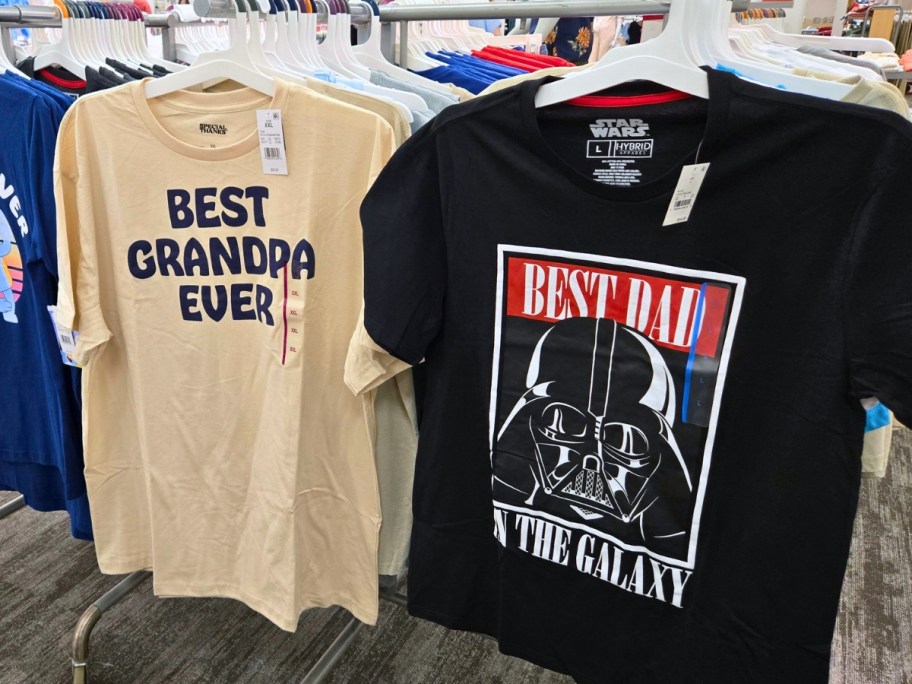 2 Father's day tshirts on a store rack, one is tan with "Best Grampa Ever" and one is black with Darth Vader and "Best Dad in the Galaxy" on it
