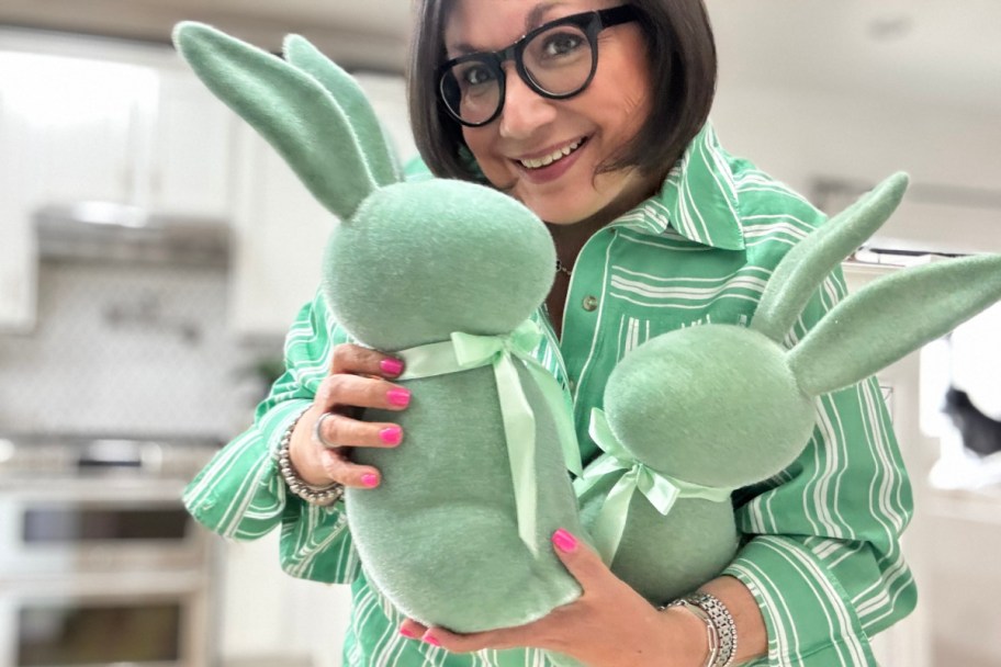 woman holding two sage green bunnies