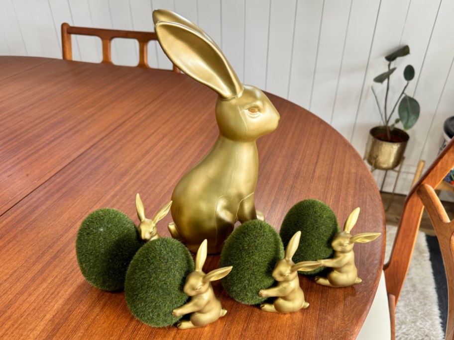 tall gold bunny surrounded small bunnies with grass eggs