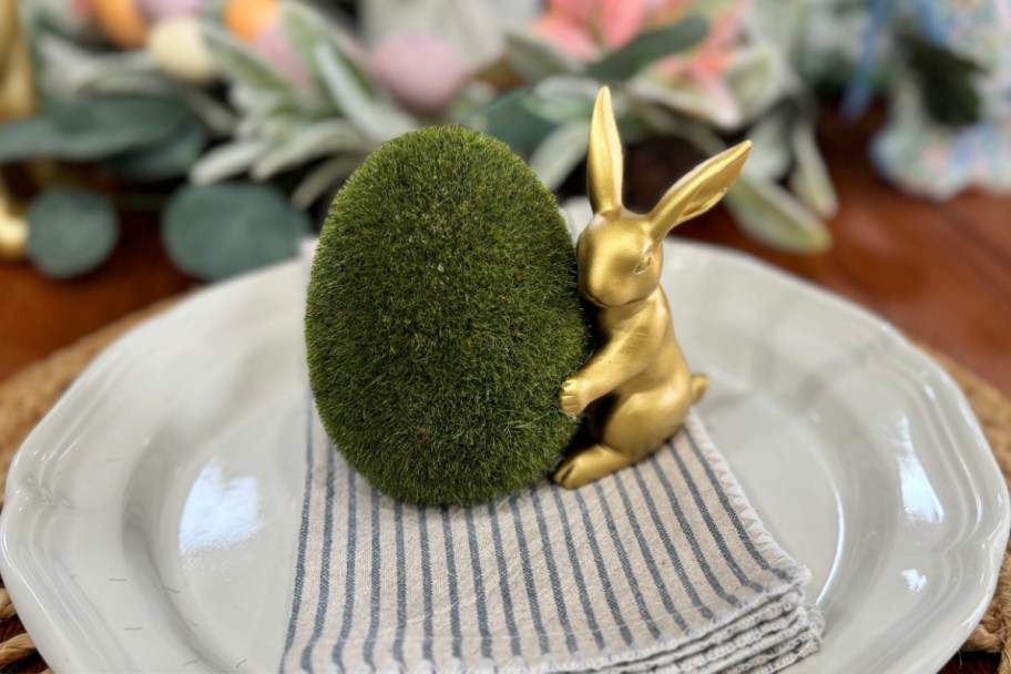 gold bunny hugging grass egg on plate