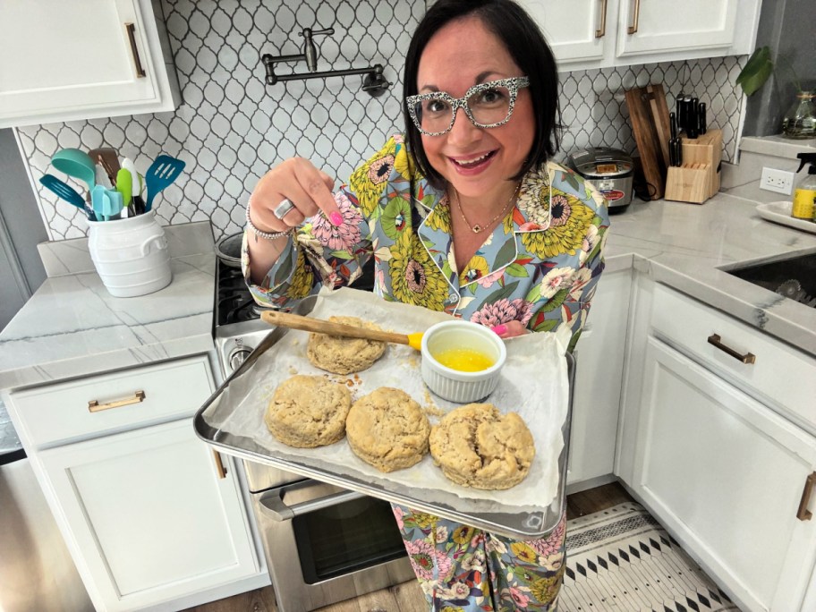 woman holding a tray of homemade sourdough biscuits 