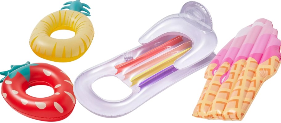 strawberry and pineapple pool floats, a large white and multicolor pool float and an ice cream cone pool float