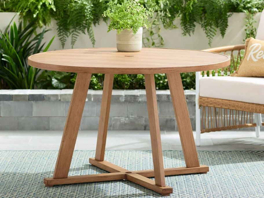 A metal table that looks like wood with a small plant on top 