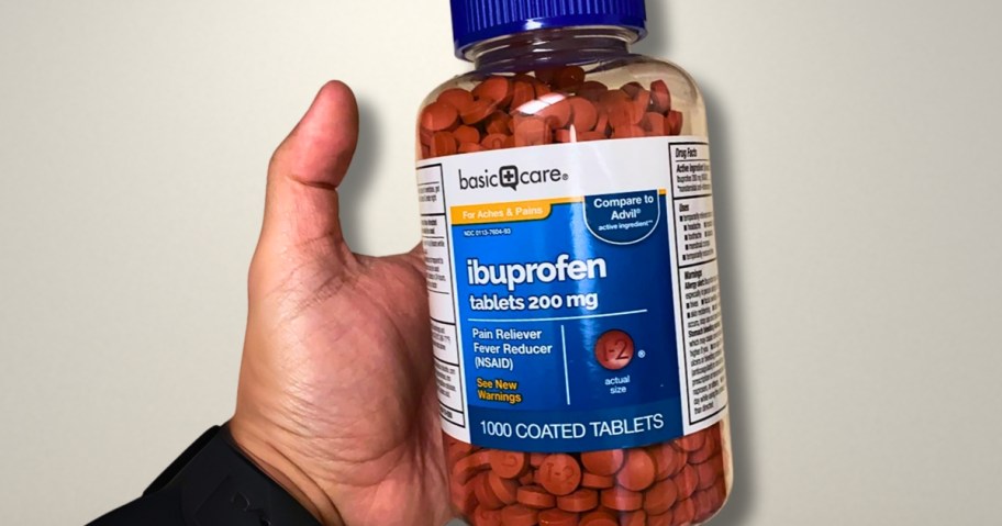 hand holding a large bottle of Amazon Basic Care 200mg Ibuprofen Tablets