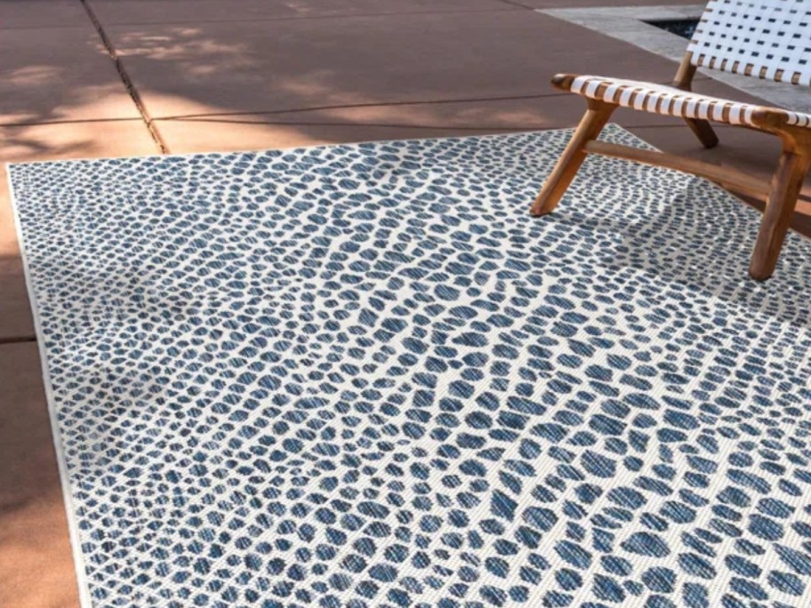 a blue and white pattern outdoor rug on a patio