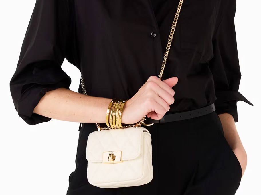 woman in black outfit with small white quilted crossbody bag