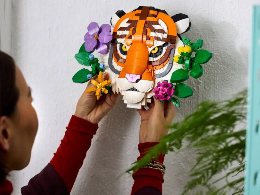 Woman hanging up a a LEGO Art The Fauna Collection Tiger on a wall
