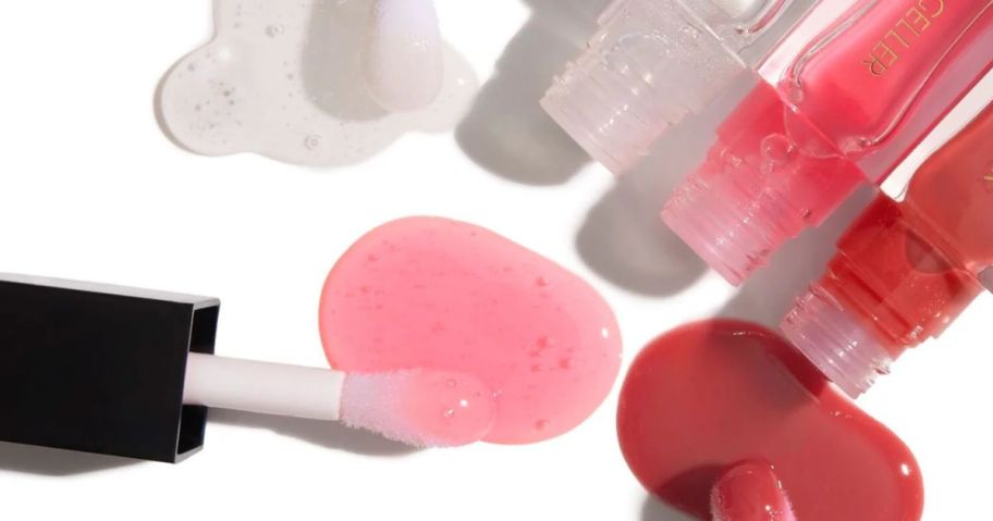 Laura Geller Fine Shine Glossy Lip Oil tubes spilled out on a counter