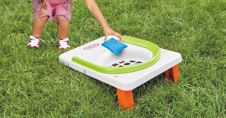Child playing with the Little Tikes My First Cornhole Game in a yard