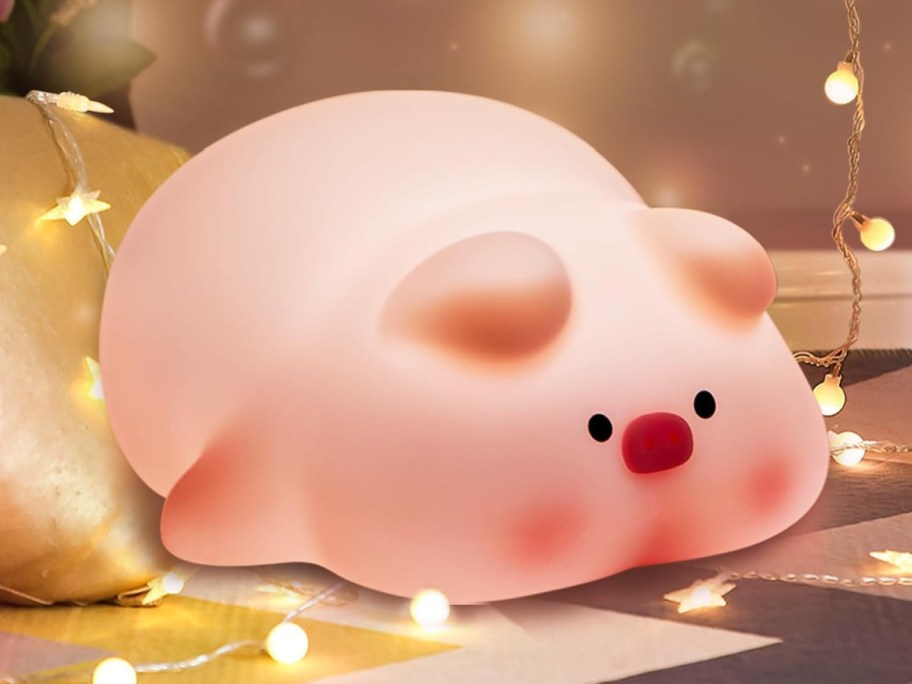 Piggy night light displayed on the floor with string lights