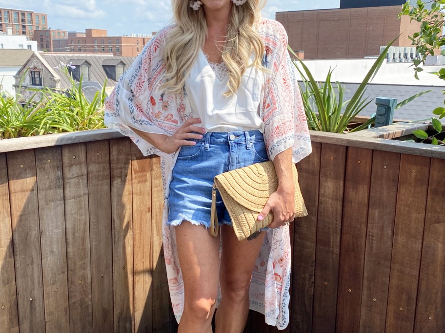 woman wearing kimono over white top and denim shorts
