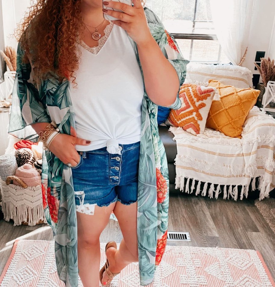 woman wearing pineapple print kimono over white top and denim shorts