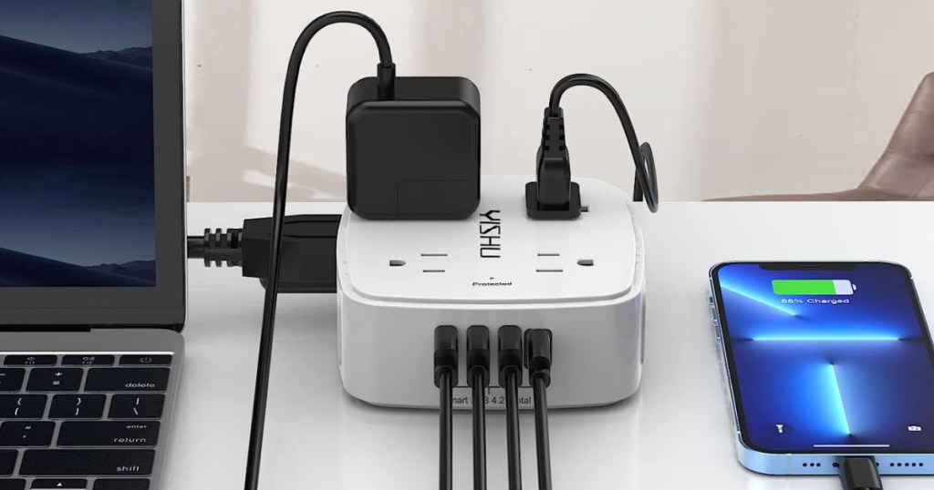 White power strip with black USB cords and black plugs, charging onlineputer and phone