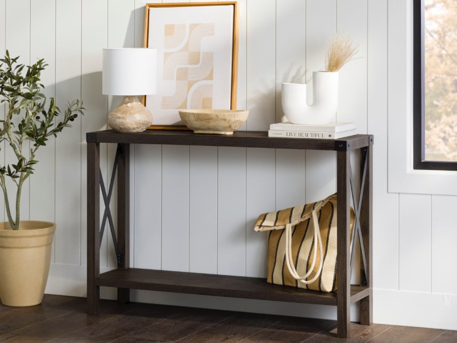 entryway table with an open shelf and items on there