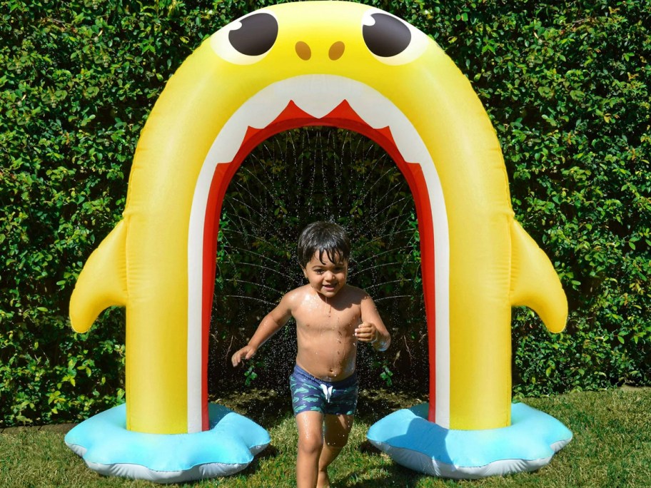 kid running under baby shark arch sprinkler