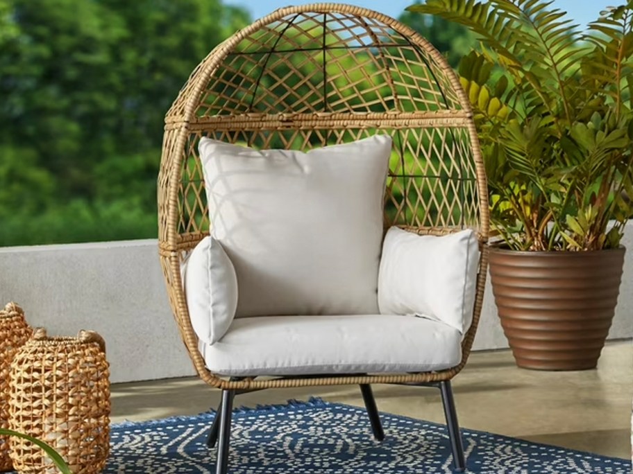 tan kids egg chair with white cushion on patio 
