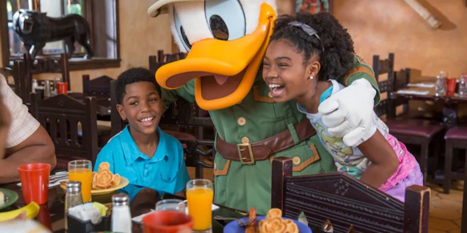 two kids eating with donald duck