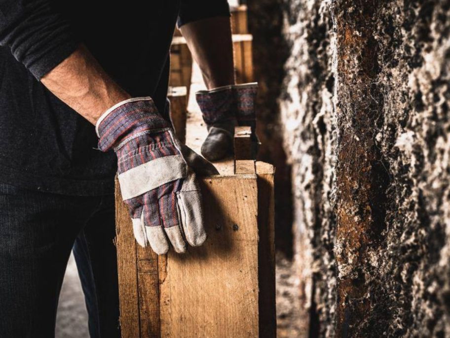 person wearing Firm Grip Leather Palm Gloves and holding wood pieces