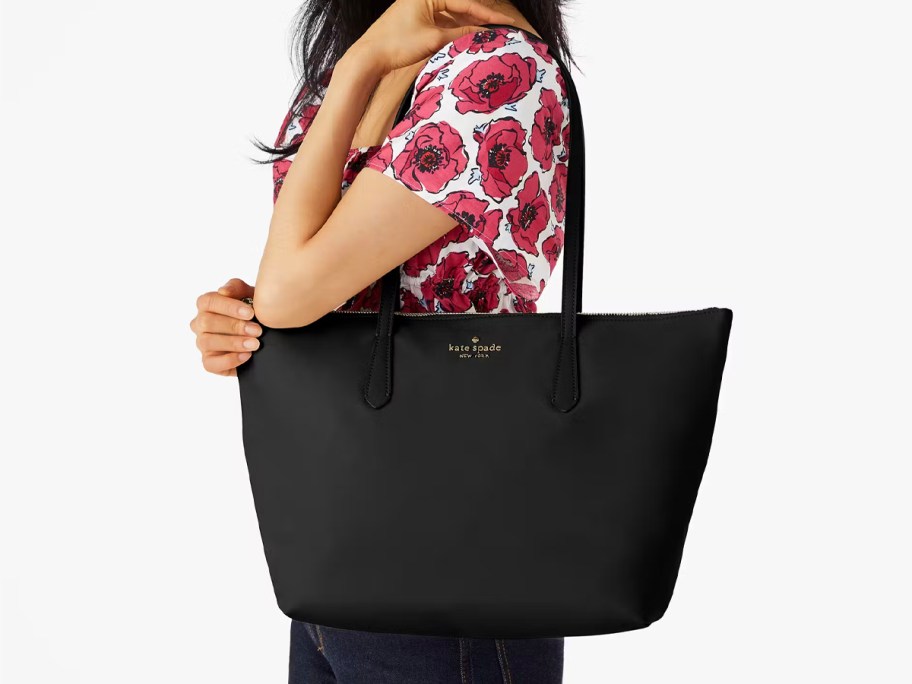 woman holding large black tote 
