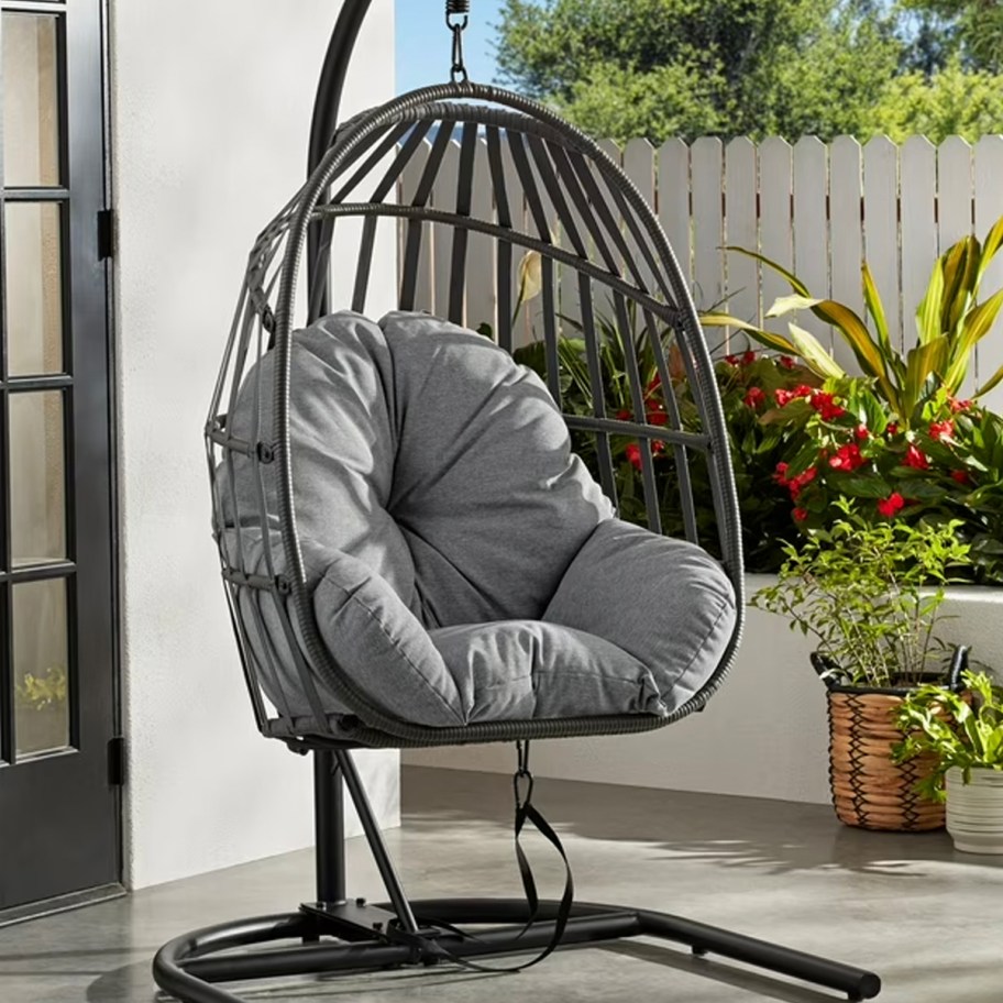gray wicker hanging egg chair on patio 