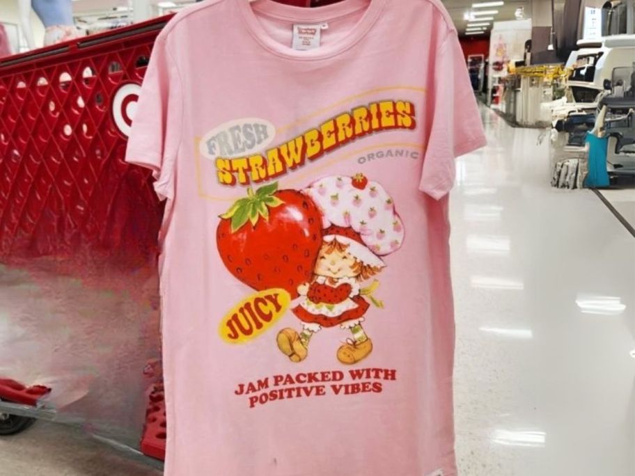 a strawberry shortcake Skinnydip Women's Oversized Graphic T-Shirt Dress hanging on cart in store