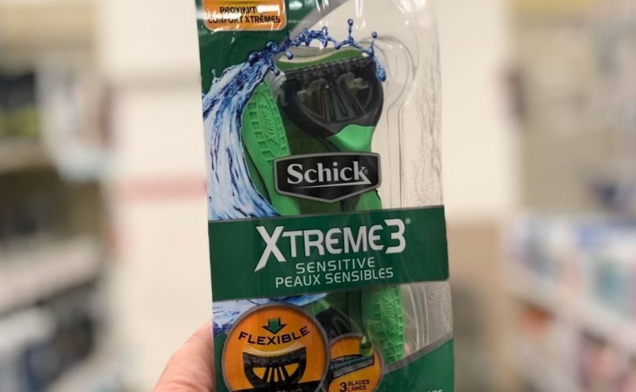 a womans hand holding a 4 pack of disposable razors