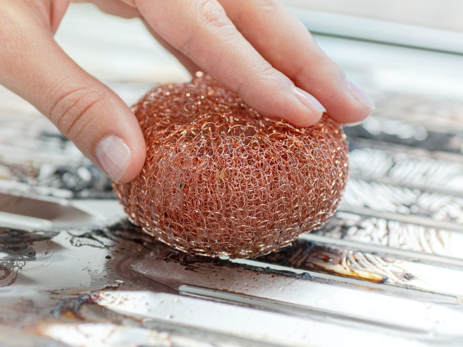 scrubbing a broiler with a copper scrubber
