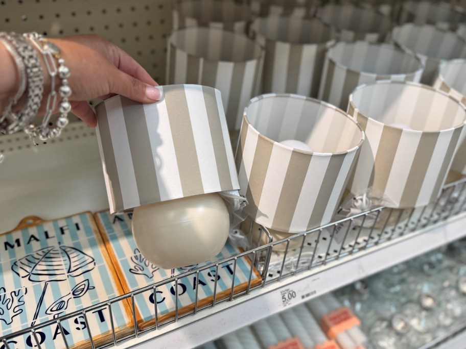 a grey and white striped mini lamp in hand in store