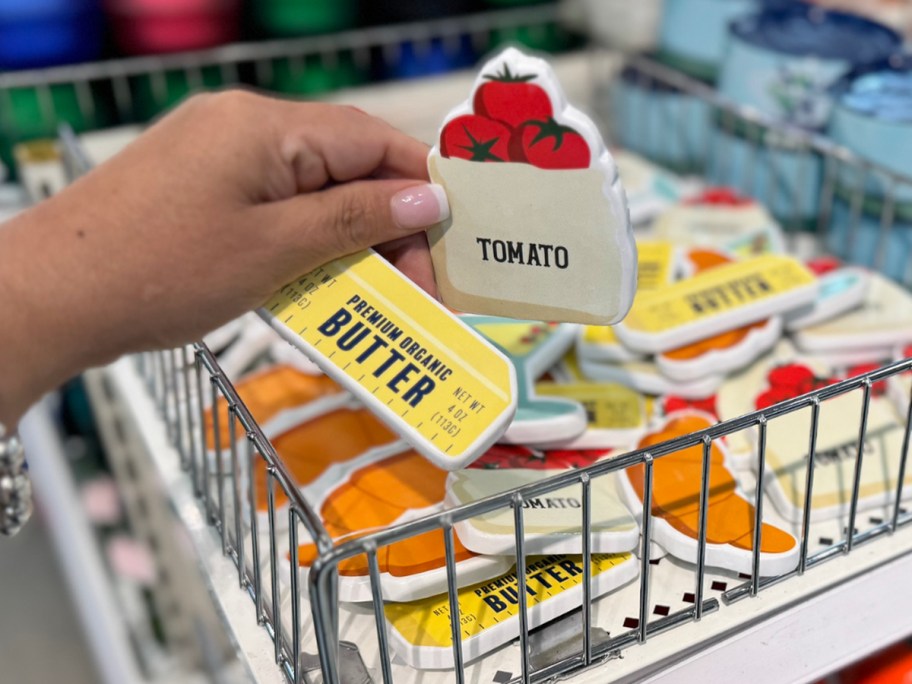 a tomato and butter magnet in hand in store