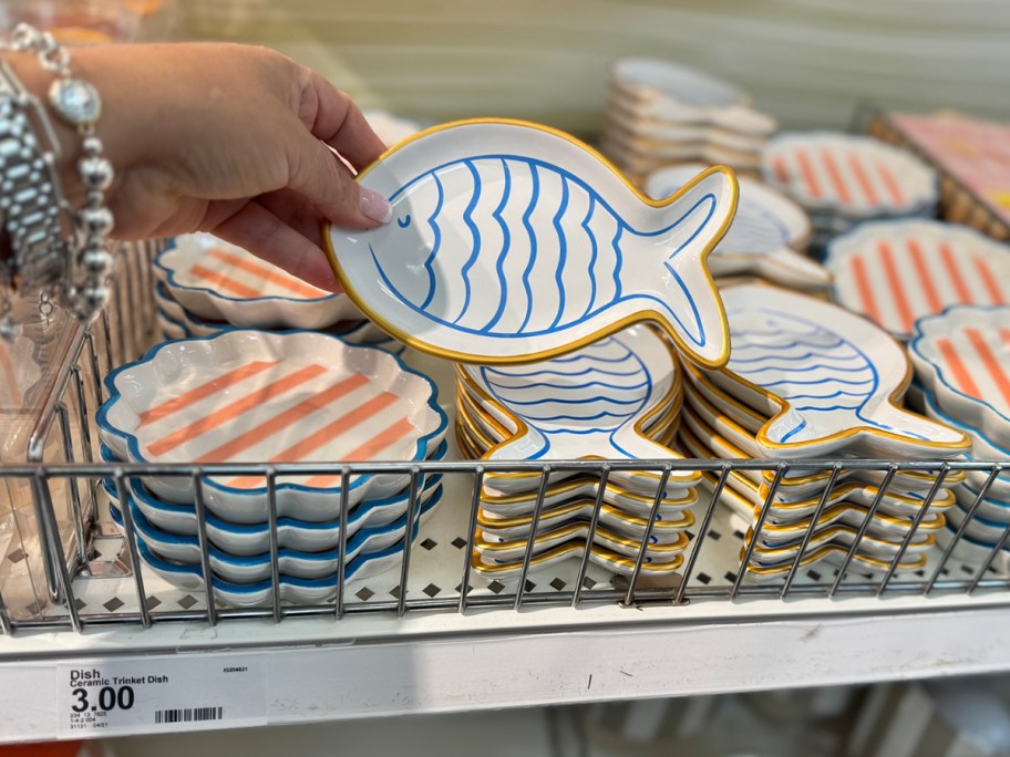 blue, white, and orange fish shaped ceramic trinket dish in hand in store