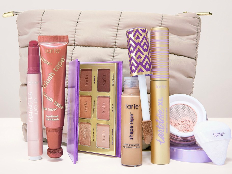 tan makeup bag with 6 tarte makeup products standing in front of it 