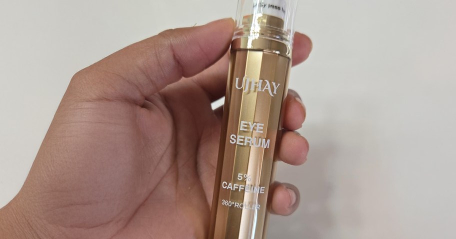hand holding a tube of eye serum