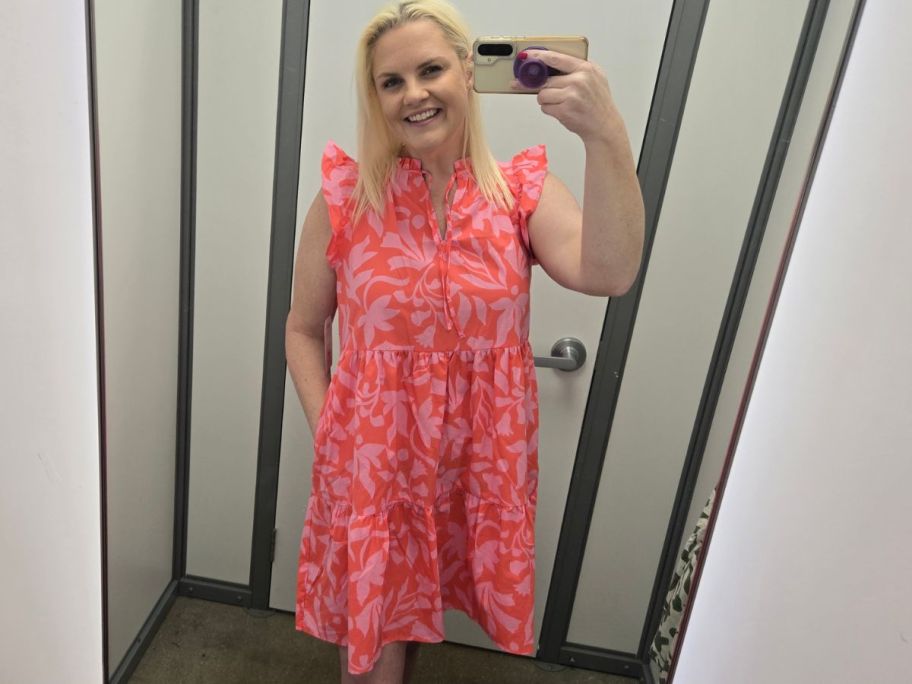 woman taking selfie in the mirror wearing a coral Flutter Sleeve Mini Dress
