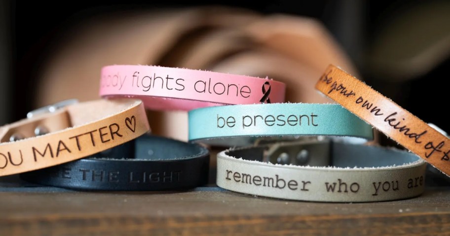 a stack of engraved leather bracelets