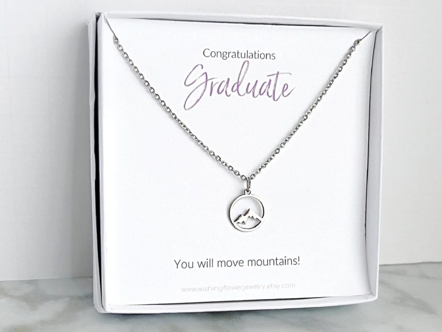 a box with a mountain charm silver necklace