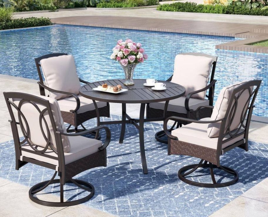 a 5 piece dining set next to a pool