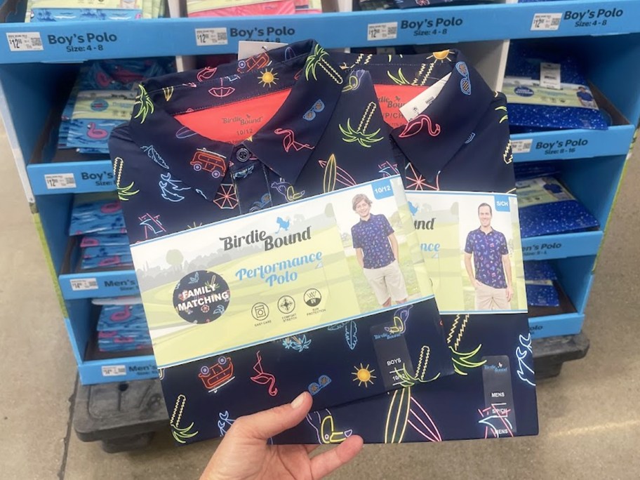 hand holding up a set of matching men's and boys polo shirts