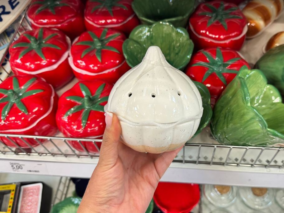 A person holding ceramic garlic bulb 