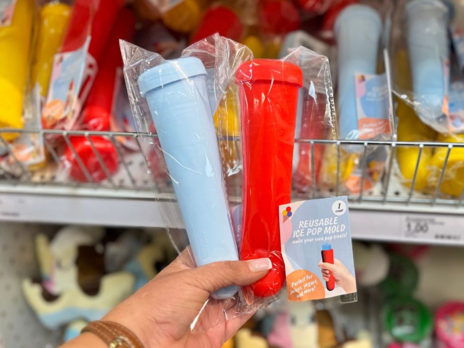 A person holding blue and pink ice pop molds