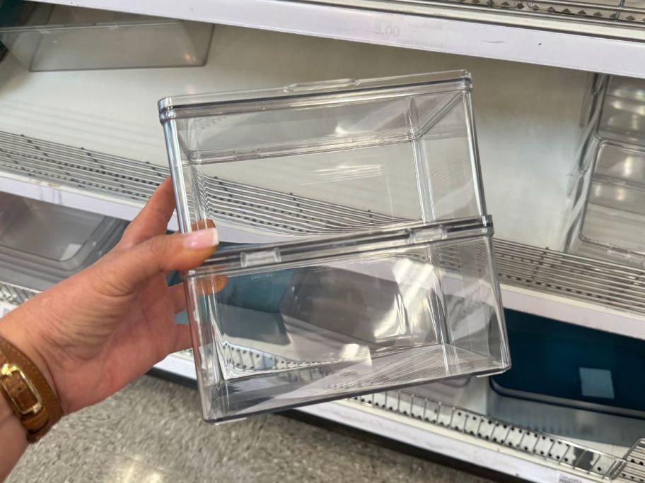 A person holding plastic bins 