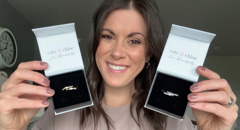 woman holding two boxes of earrings in front of her