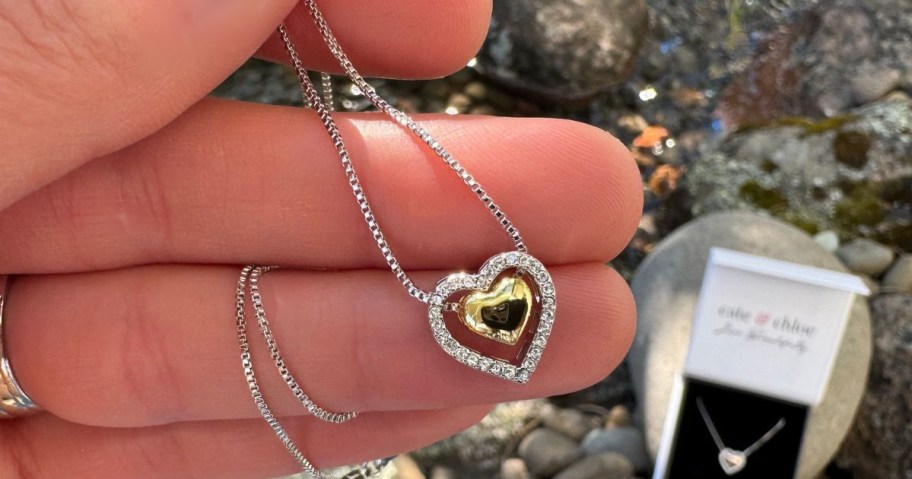 Hand holding a Cate & Chloe Susan Heart Pendant Necklace
