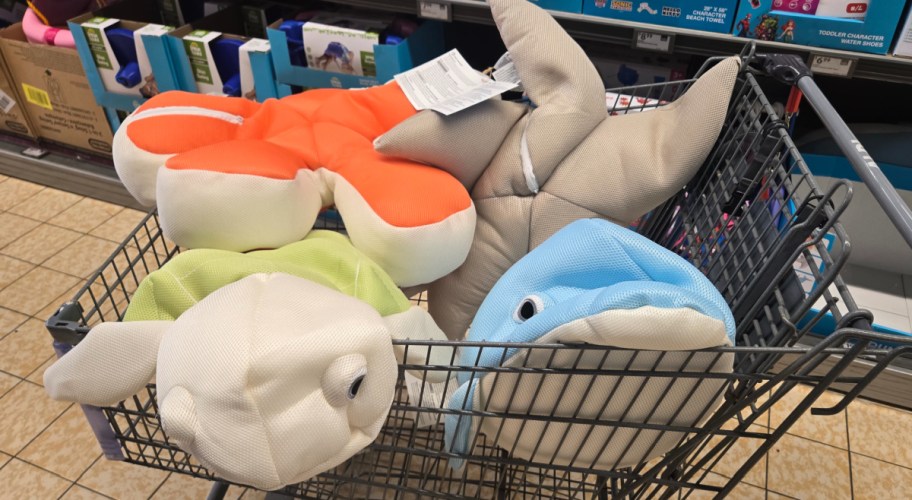 shopping cart filled with pool animals inside of it