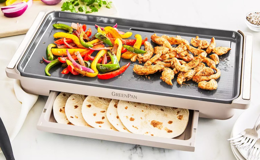 fajita veggies and meat on top of griddle with tortillas inside warming drawer
