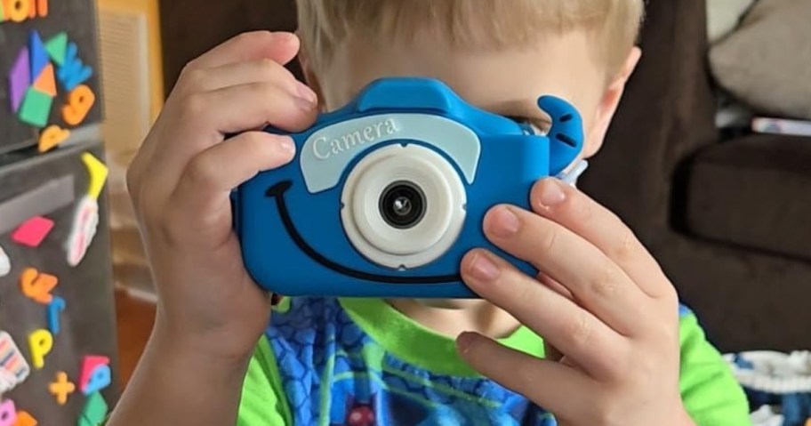 little boy holding a blue kids digital camera