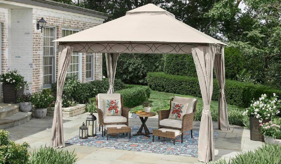 gazebo with curtains and chairs underneath 