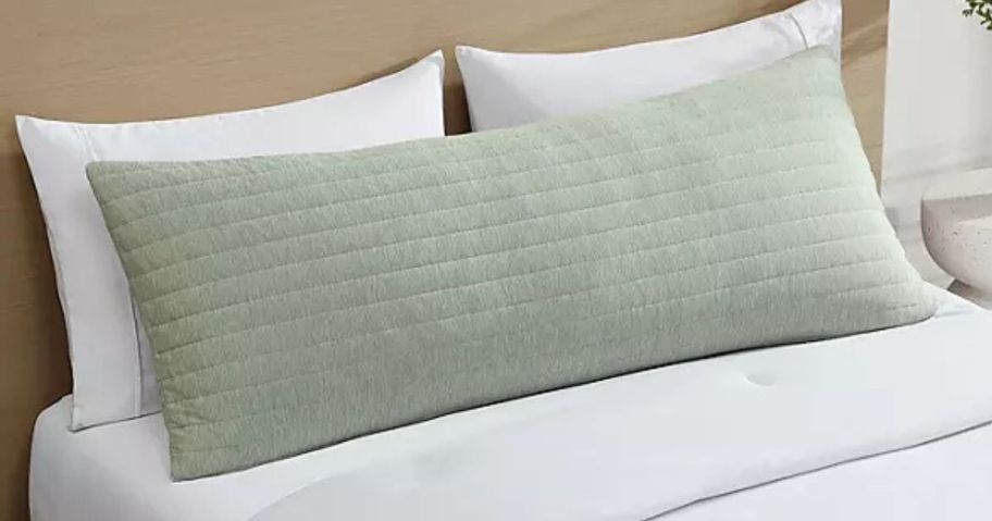 A green Hudson & Main cooling body pillow on a bed