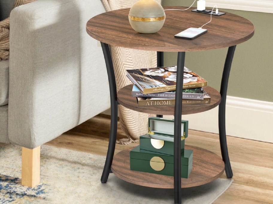 End of table with3 shelvies with books and items displayed on it 